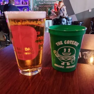 a glass of beer and a plastic cup