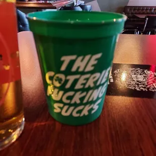 a green cup and a glass of beer