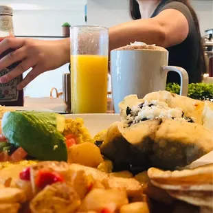 a woman sitting at a table with a plate of food