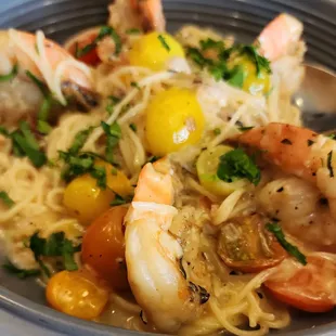 a plate of pasta with shrimp and vegetables