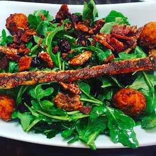 Fried Goat Cheese Salad- Organic arugula, bacon, dried cranberries, candied pecans, drizzled with our brown butter vinaigrette.