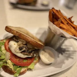Chicken burger on sourdough bread with lettuce, tomato&apos;s, and grilled o ions &amp; mushrooms, and sweet potato fries