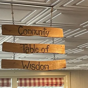 three wooden signs hanging from the ceiling
