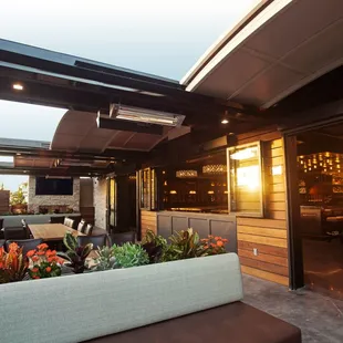 The Country Club's spacious patio with secluded lounge areas, complete with a flickering fireplace and remote opening roof panels!