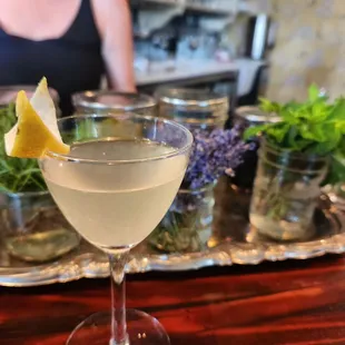 French 75 with fresh bouquets of herbs in the background