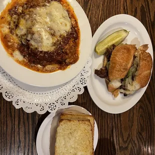 Homemade Lasagna with homemade sauce along with garlic bread and an alpine Swiss sandwich