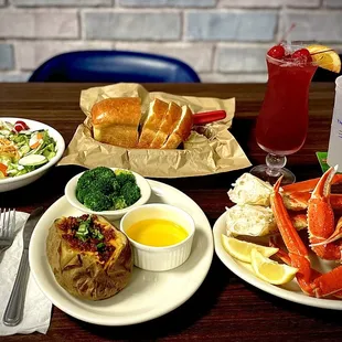 crab legs, potatoes, salad, and a drink
