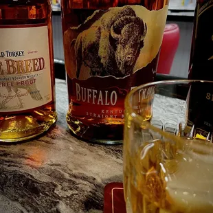two bottles of bourbon and a glass of whiskey
