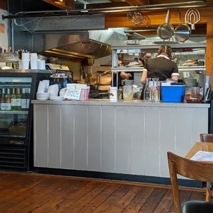 a restaurant kitchen with a counter and chairs