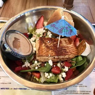 Delicious grilled salmon salad with goat cheese and strawberries, Key Lime onion dressing on the side.