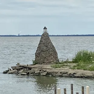 a lighthouse on a small island in the middle of the water