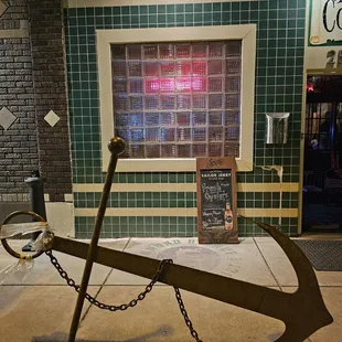 a large anchor on a sidewalk
