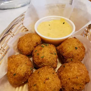 Hush puppies served with seasoning similar to good times sauce. Good but a little doughy