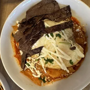 Red chilaquiles with eggs and steak