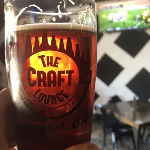 a hand holding a glass of beer