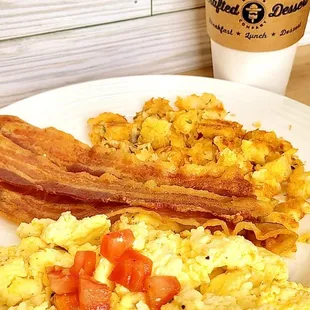 Scrambled eggs , bacon or sausage with hash browns and toast.