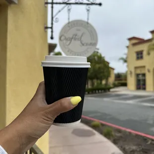 a hand holding a cup of coffee