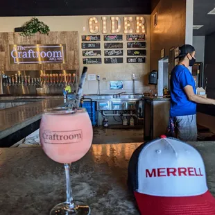 a glass of wine and a baseball cap