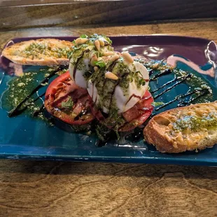 Burrata with Roma tomatoes, pine nuts, balsamic glaze, pesto and olive oil