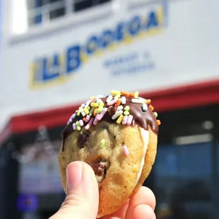 a hand holding a chocolate covered doughnut