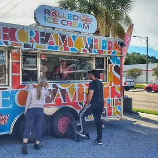 two people standing in front of an ice cream truck
