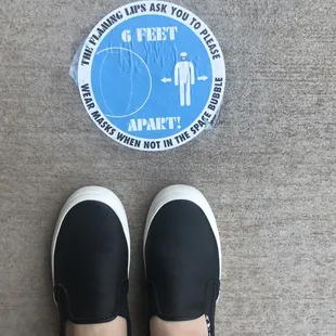 a person standing on a sidewalk with a sticker on the ground
