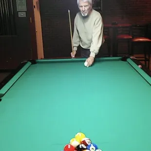a man leaning over a pool table