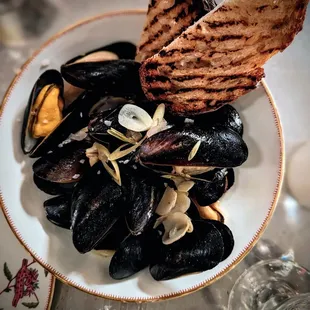 a plate of mussels and bread