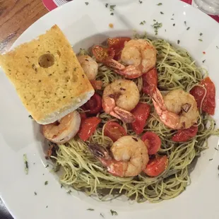a plate of pasta with shrimp and tomatoes