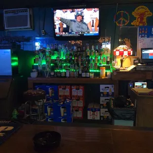 a bar with a television and green lights