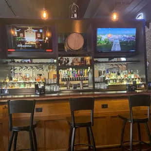 a row of bar stools in front of a television