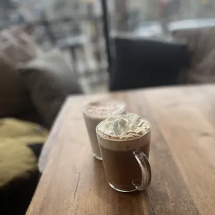 two cups of coffee on a wooden table