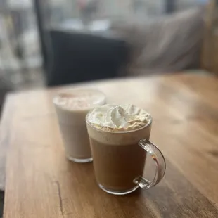 two cups of coffee on a wooden table