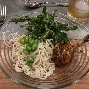a glass plate with noodles, meat and vegetables