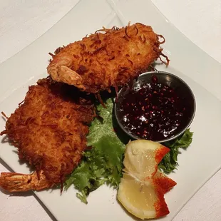 a plate of fried shrimp with a side of sauce