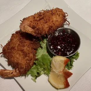 a plate of fried shrimp with a side of sauce