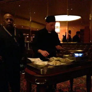 two men standing in front of a buffet