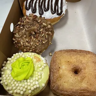 Donut with a moon pie inside, maple walnut cake, pistachio, cronut.