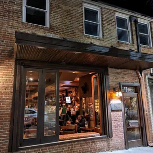 Outside. Storefront at night. Low key. The Crunkleton is located between Tropical Smoothie Cafe (The Book Shop) and Tea Hill (Cha House).