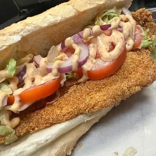 a fish sandwich with tomatoes and lettuce