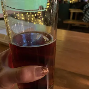 a person holding a glass of beer