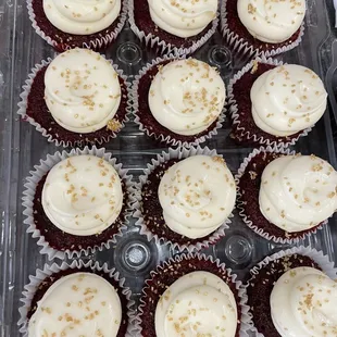 A dozen red velvet with gold sprinkles cupcakes