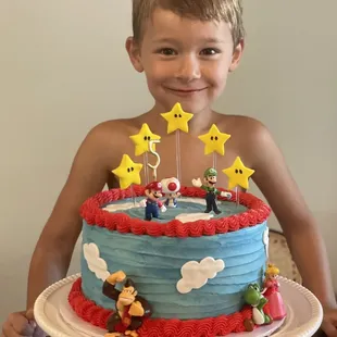 a young boy holding a cake