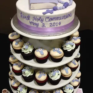 a three tiered cake and cupcakes