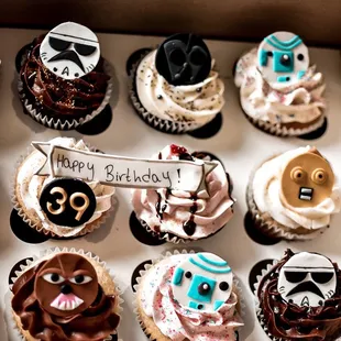 a box of decorated cupcakes