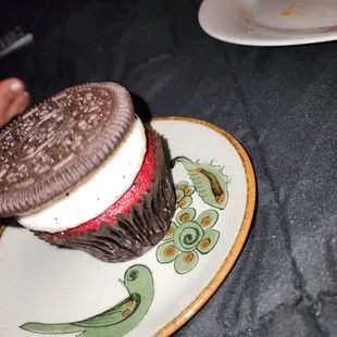 a chocolate cupcake with an oreo sandwich on it