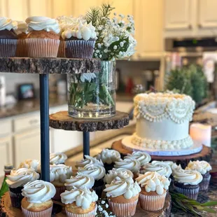 a three tiered cake and cupcakes