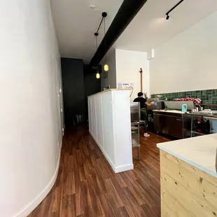 a kitchen with wood flooring and white walls