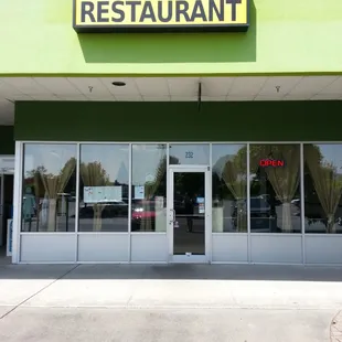 The restaurant front, located in strip mall.