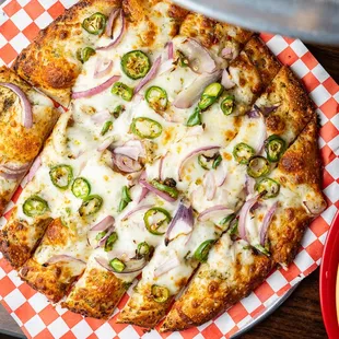a pizza with onions and jalapenos